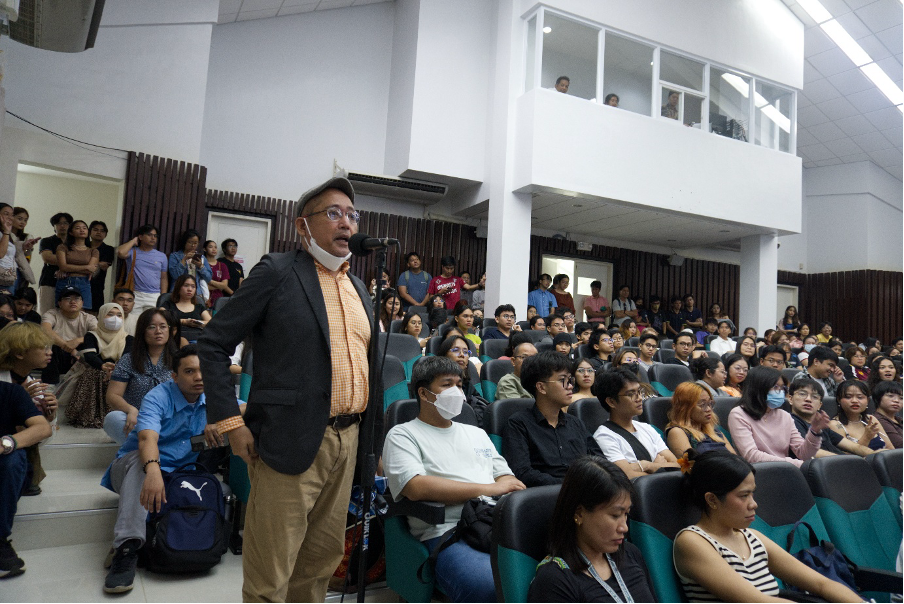 An audience member asking a question to Prof. Otsuka.